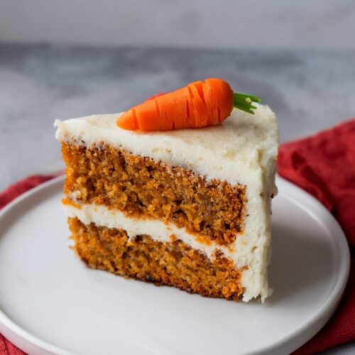 This Carrot Cake is ultra-moist, packed with warm spices, fresh carrots, and crushed pineapple, then slathered in the creamiest cream cheese frosting!